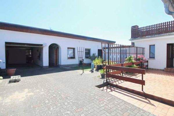 Innenhof mit Terrasse, Garage, Eingang Haupthaus, Eingang Einliegerwohnung und Dachterrasse