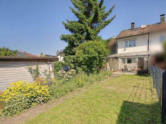 Hausansicht vom Garten mit überdachter Terrasse
