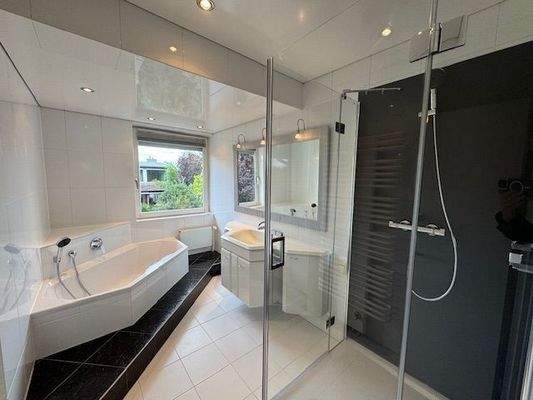 Das neuwertige Bad mit Dusche und Eckbadewanne