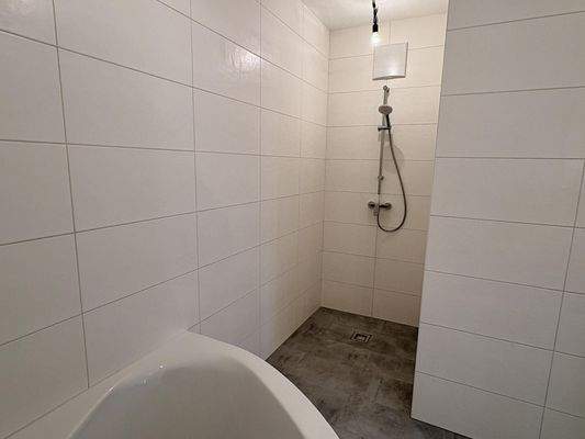 Badezimmer mit Badewanne und Dusche