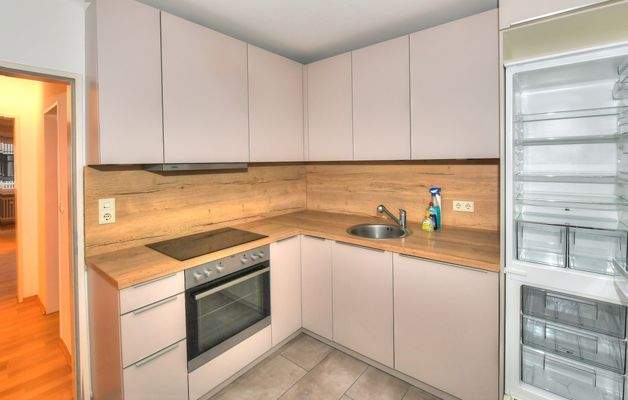 Küche mit neuerer Einbauküche und Platz für Waschmaschine und Trockner