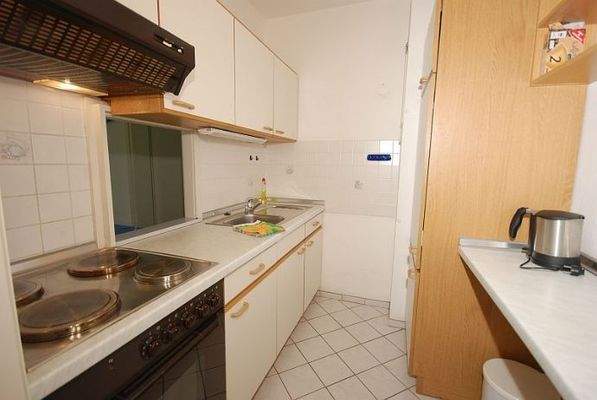 Küchenraum mit Einbauküche und Durchreiche