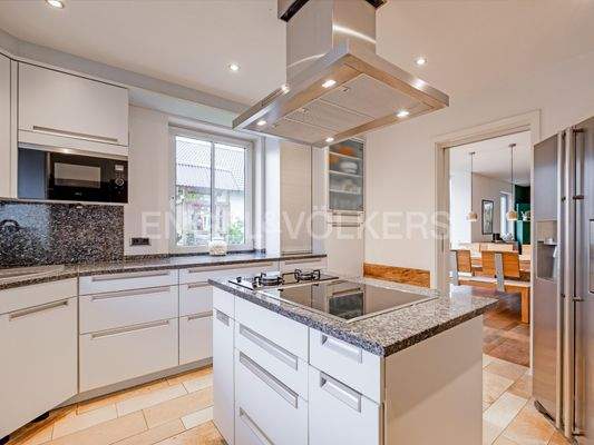 Blick von der Küche ins Wohnzimmer mit Sitz- und Essgelegenheiten