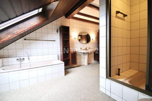 Badezimmer mit Wanne und Duschbereich