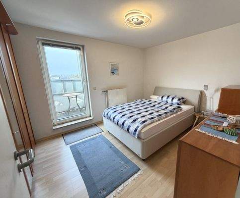 Helles Schlafzimmer mit Balkonzugang und durchdachter Raumaufteilung