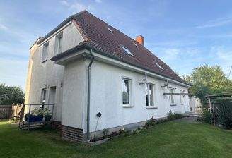Rückwärtige Hausansicht vom Grundstück,
seitlicher Eingang der Wohnung WE 3