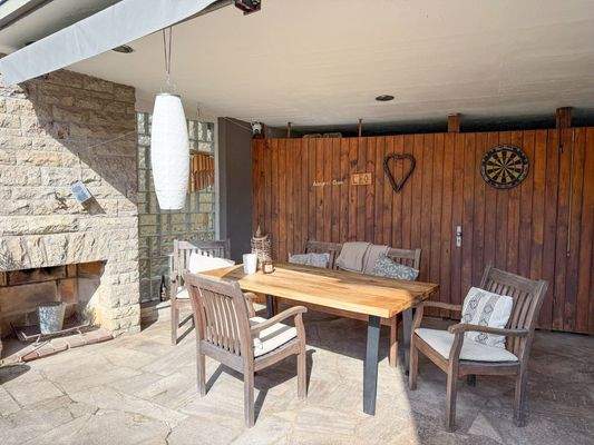 Überdachte Terrasse mit offenem Kamin