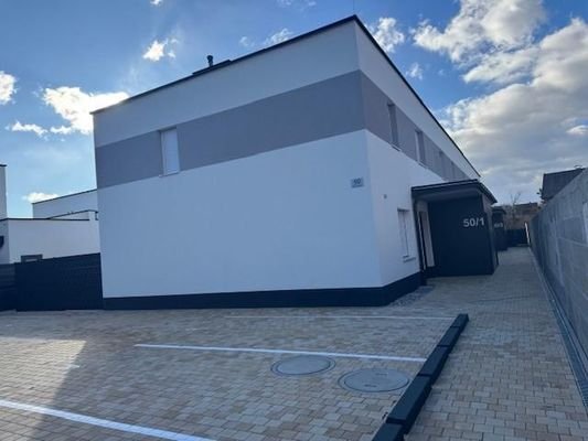 Parkplatz vor der Anlage mit nur 4 Reihenhäusern
