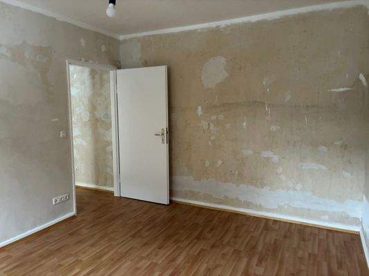 Schlafzimmer/Wohnzimmer mit PVC-Bodenbelag in Holzoptik mit tapezierfähigen Wänden.