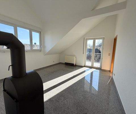 Lichtdurchflutetes Wohnzimmer mit Kaminofen und direktem Terrassenausgang