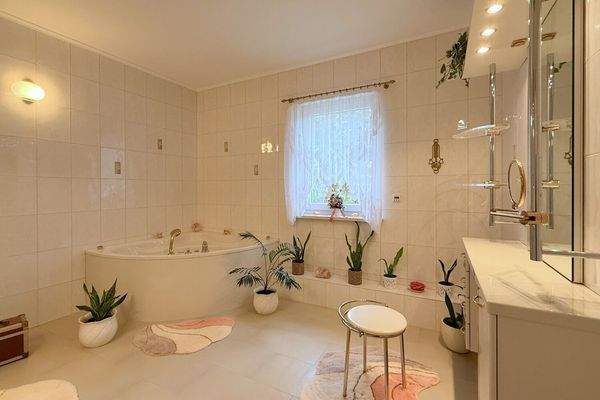 Badezimmer mit Eckbadewanne und Schminktisch