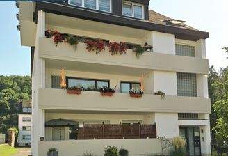  Frontansicht Haus mit oberem Balkon (rote Blumen)