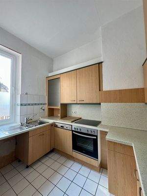 Küche mit Einbauküche und Fenster