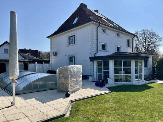 Rückwärtige Seitenansicht des Hauses mit Wintergarten und Pool