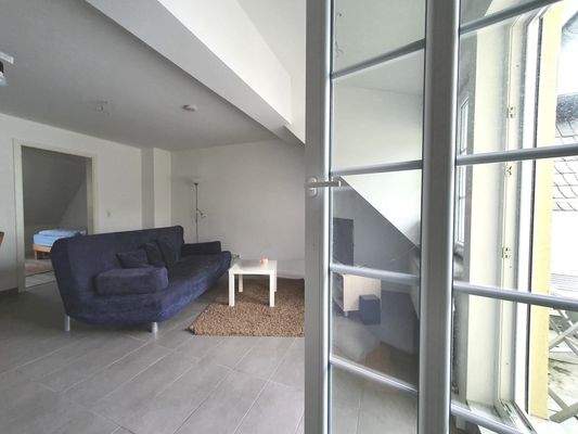 Offener Wohnbereich mit Zugang zum Balkon