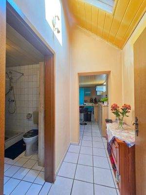 Wohnungseingang mit Blick ins Duschbad und offene Küchem it Wohnen und Essen