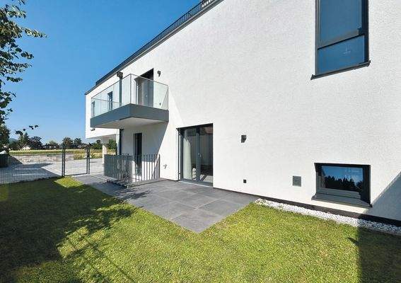 sonniger Garten mit großer Terrasse