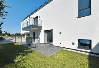 sonniger Garten mit großer Terrasse