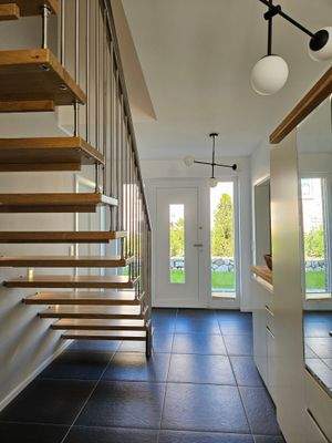 Heller Eingangsbereich - offene Holzwangentreppe