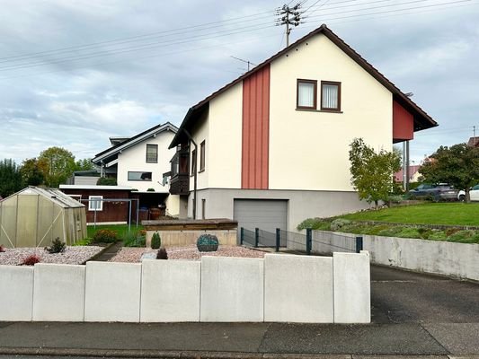 Ansicht mit Garten und Garage