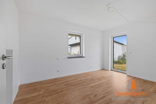 Blick ins Schlafzimmer mit Zugang zum Garten