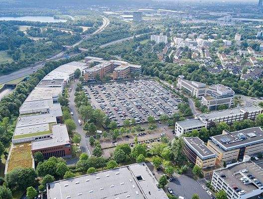 Luftbild Gebäudekomplex + Parkplätze