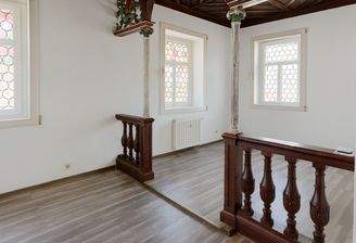 Stilvolle Galerie im Wohnzimmer mit antiken Säulen und kunstvoll gearbeiteter Holzbalustrade