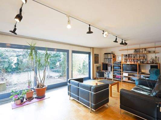 EG: Lichtdurchfluteter Wohnbereich mit großer Fensterfront zum Garten