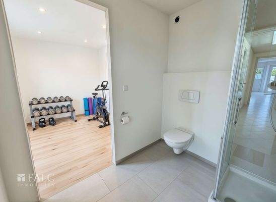 Fitnessraum / Abstellbereich mit Toilette und Dusche - (KI generiert)