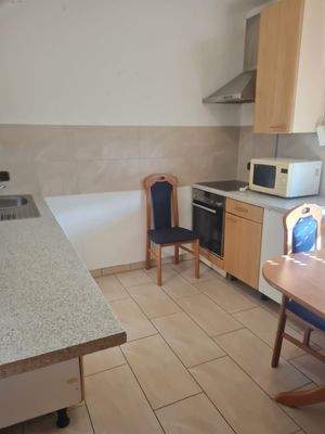 Küche mit Einbauküche, groß genug für Tisch und Stühle, Fliesenboden