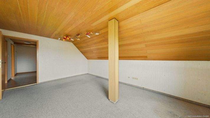 Gemütlich unterm Dach: Wohnzimmer mit Zugang zum Balkon