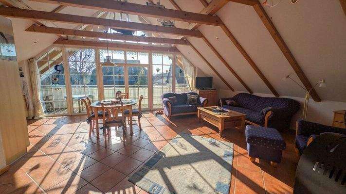 Wohn- und Esszimmer im Dachgeschoss mit Zugang zum Balkon