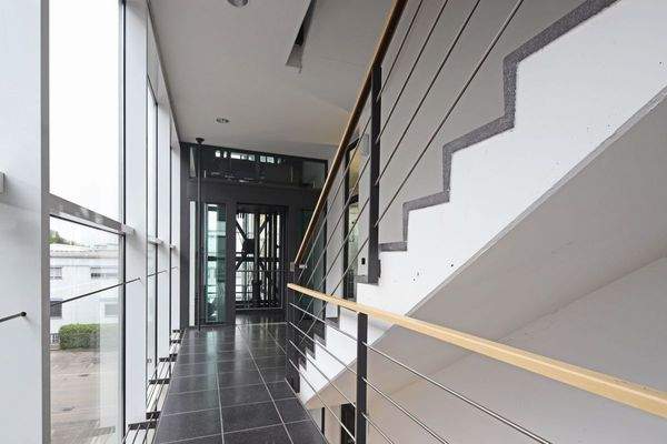 Treppenaufgang mit Glasaufzug