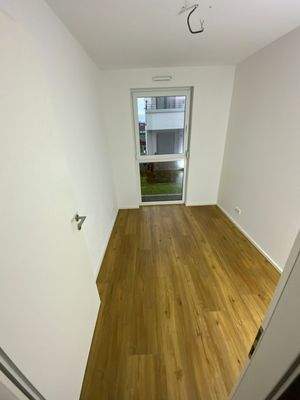 3. Zimmer mit Vinylboden in Holzoptik und weißen Wänden 