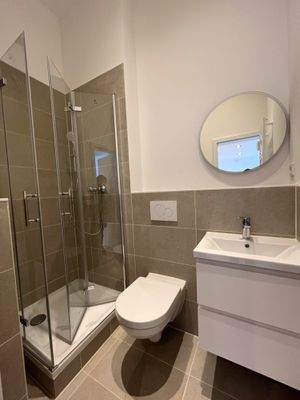 Saniertes Bad mit Duschkabine, Spiegel und Waschtischunterschrank