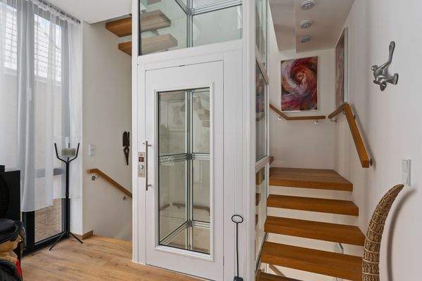 Flurbereich im Obergeschoss mit Treppe und Fahrstuhl ins Erd- und Staffelgeschoss.