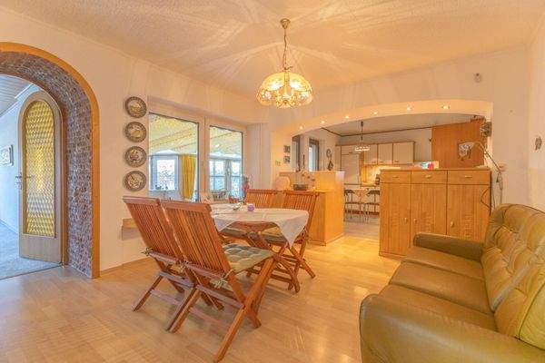 Esszimmer mit offener Küche und Zugang zum überdachten Außenbereich