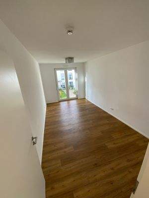 Schlafzimmer mit weißen Wänden und Vinylboden mit Holzoptik