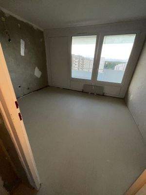 Beispielhaftes Kinderzimmer mit tapetenfreien Wänden und hellem Linoleumboden