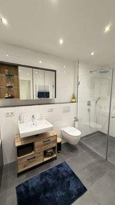 Badezimmer mit Waschbecken und großer Dusche