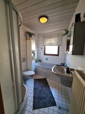 Badezimmer mit Wanne und integrierter Dusche im 2 