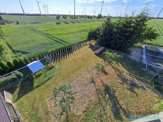 Blick auf das Grundstück im hinteren Bereich mit Bau der offenen Halle