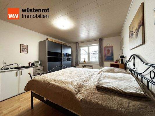 Einliegerwohnung: Schlafzimmer 1 mit breitem Doppelbett und viel Stauraum