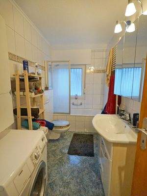 Hell gefliestes Bad mit Wanne