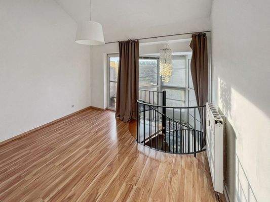 Schlafbereich mit Blick zum Treppenaufgang und Balkon