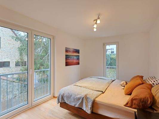 Gemütliches Schlafzimmer mit bodentiefen Fenstern