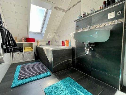 Ein Badezimmer im Obergeschoss mit Wanne...