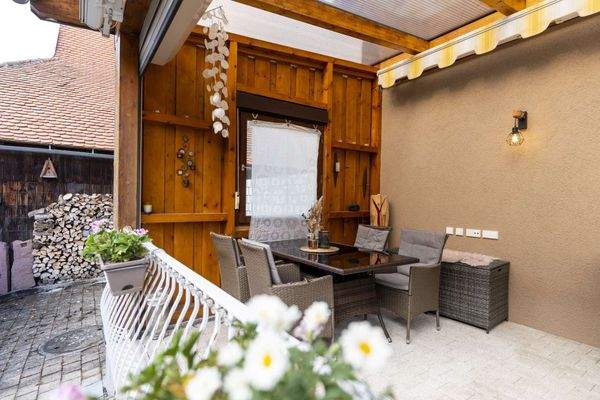 Überdachte Outdoor Lounge mit warmem Ambiente