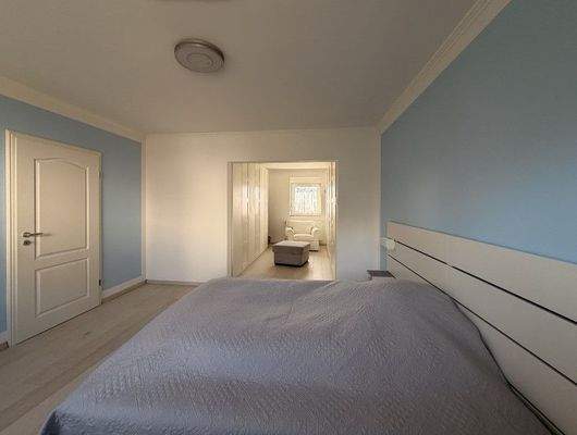 Schlafzimmer mit Blick zum begehbaren Kleiderschrank