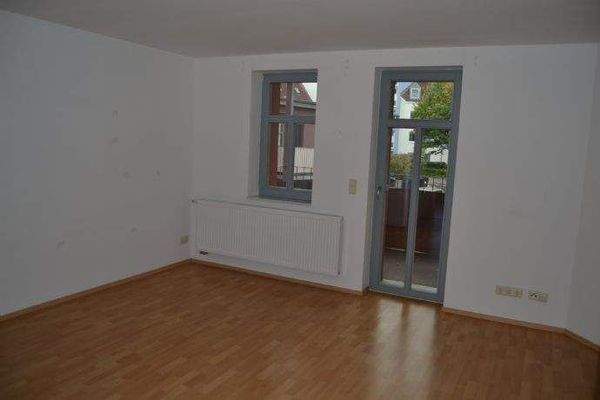 Offenes Wohnzimmer mit Küche und Balkonzugang